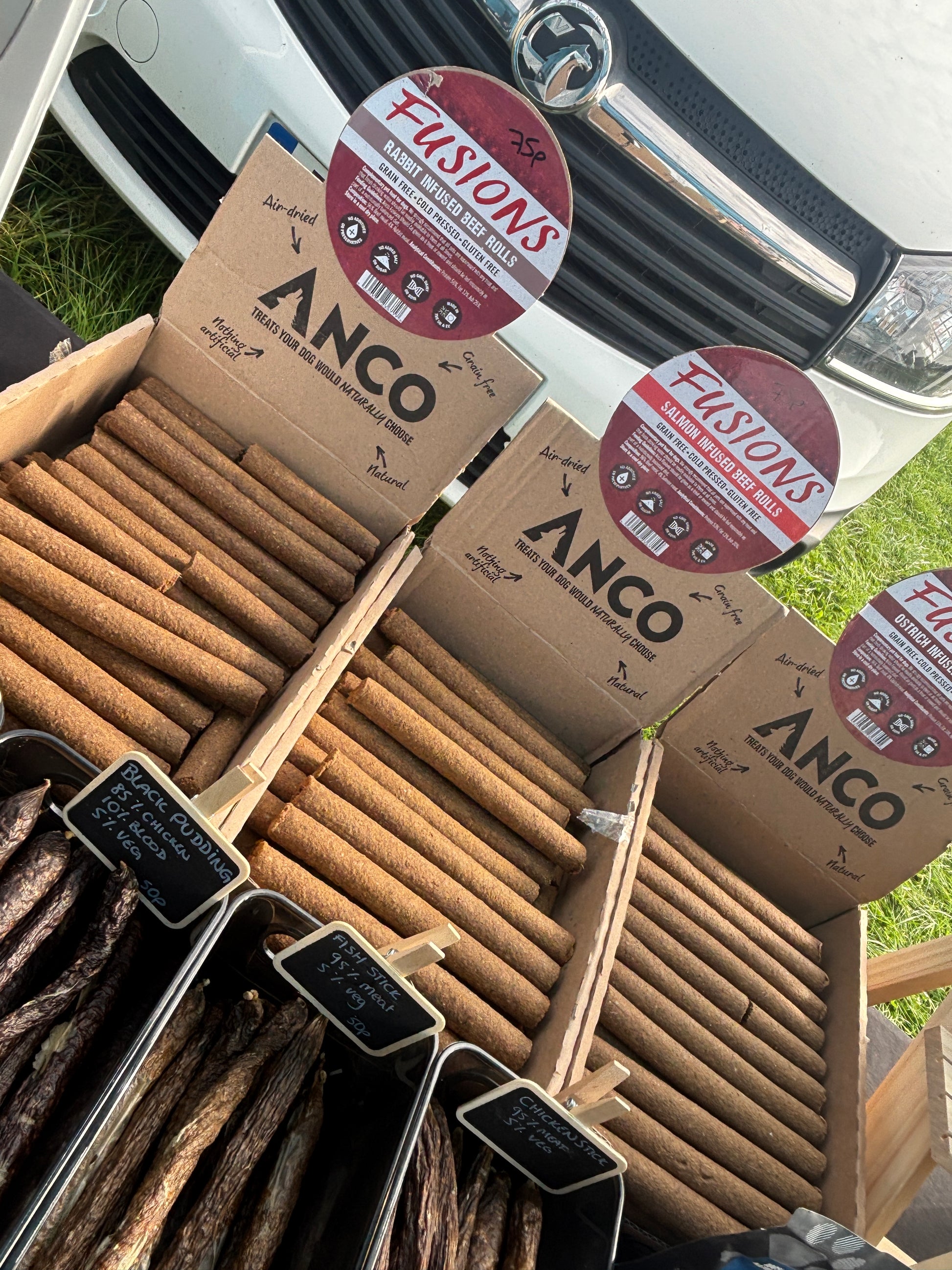 Boxes of ANCO and Fusions brand products with wooden sticks on a vehicle.